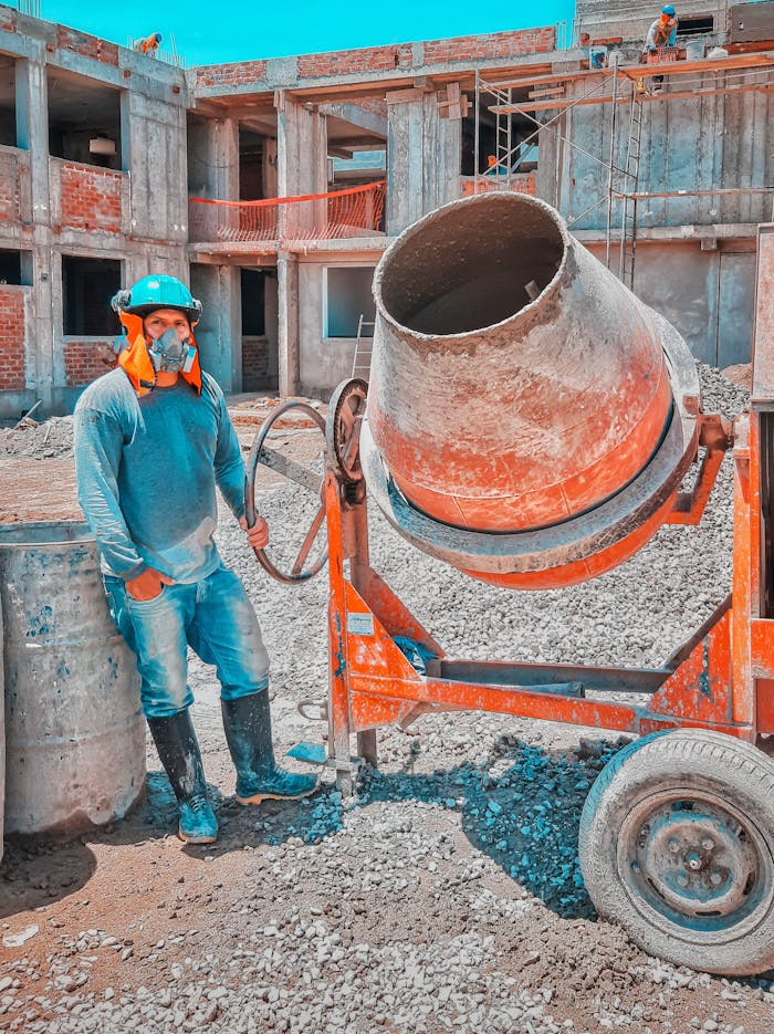 about-img Construction worker operates heavy concrete mixer on sunny outdoor site.