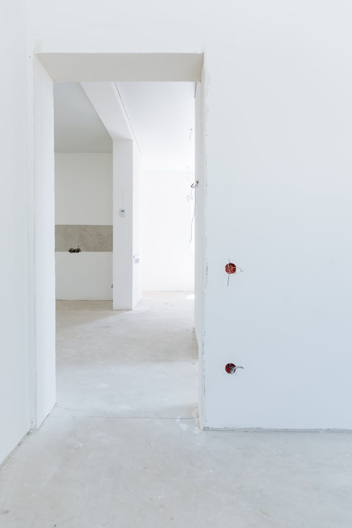 gallery-4 Bright unfinished room with white walls and exposed wiring, showcasing modern interior design potential.